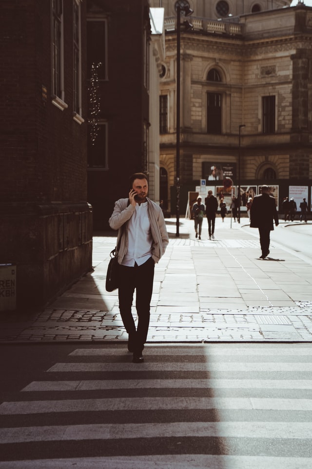 Man crossing street while on phone